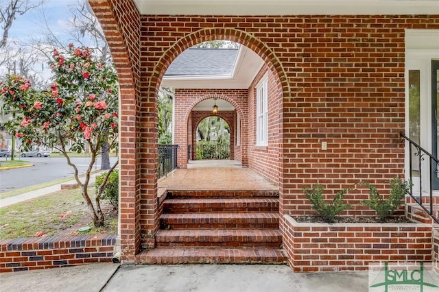 view of exterior entry featuring brick siding