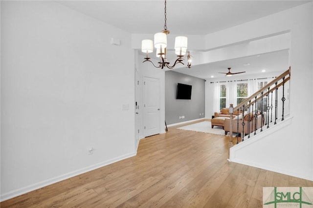 interior space with light wood finished floors, stairway, an inviting chandelier, and baseboards