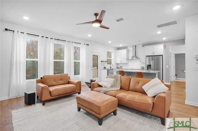 living area featuring recessed lighting, light wood-style floors, visible vents, and ceiling fan