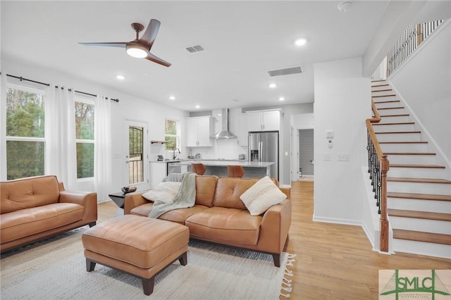 living area featuring visible vents, recessed lighting, stairs, and light wood-type flooring