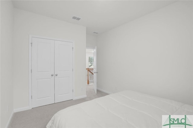 bedroom featuring light carpet, visible vents, baseboards, and a closet