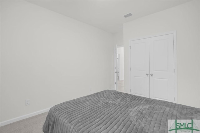 carpeted bedroom featuring a closet, visible vents, and baseboards