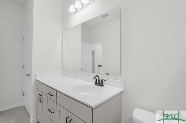 bathroom featuring visible vents, toilet, and vanity