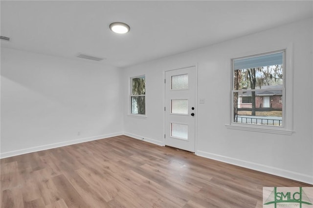 entryway with baseboards, plenty of natural light, and wood finished floors