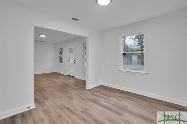 spare room with visible vents, baseboards, and wood finished floors