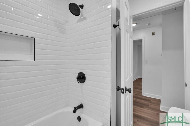 full bath featuring baseboards, bathing tub / shower combination, and wood finished floors