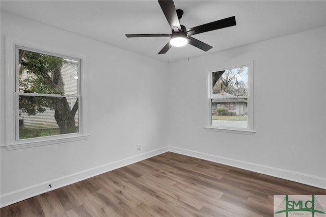 empty room with a ceiling fan, baseboards, and wood finished floors