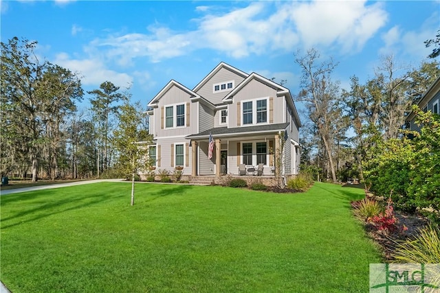 view of front facade with board and batten siding, a front lawn, and covered porch