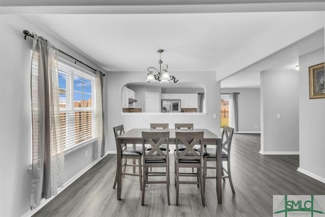 dining room featuring an inviting chandelier, wood finished floors, and baseboards