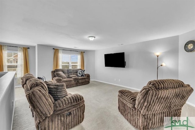 carpeted living room featuring a healthy amount of sunlight and baseboards