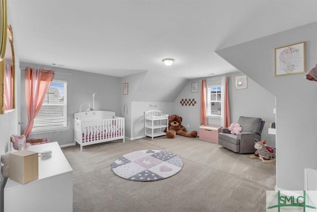 bedroom featuring a nursery area, multiple windows, lofted ceiling, and carpet floors