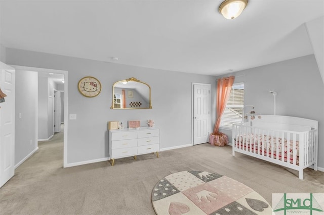 unfurnished bedroom with a crib, carpet, and baseboards