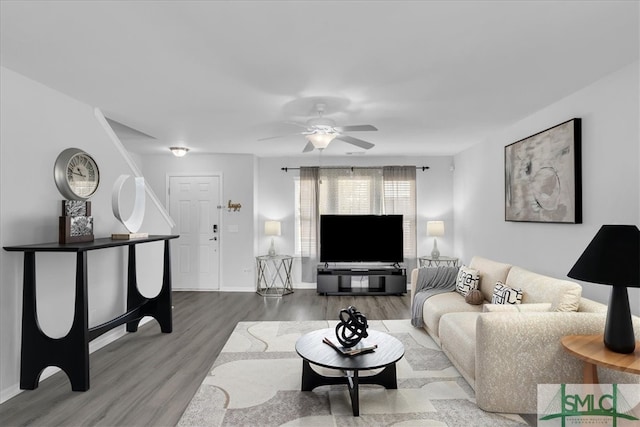 living area with ceiling fan, baseboards, and wood finished floors