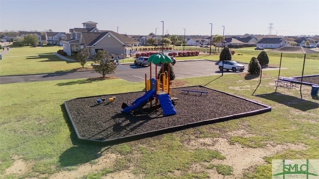 view of community with playground community, a lawn, a residential view, and uncovered parking