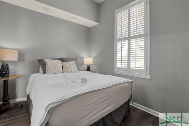 bedroom with baseboards and dark wood-style flooring