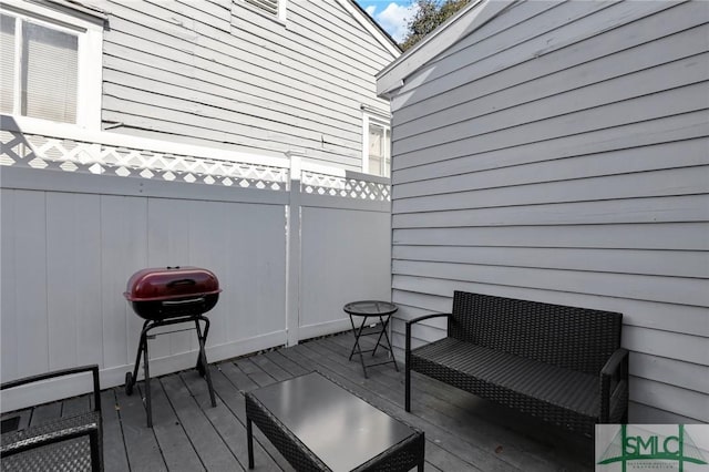 wooden terrace with a grill and fence