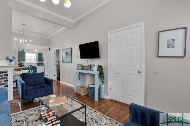 living area featuring an inviting chandelier, wood finished floors, baseboards, and ornamental molding