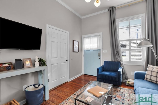 living room with wood finished floors, baseboards, and ornamental molding