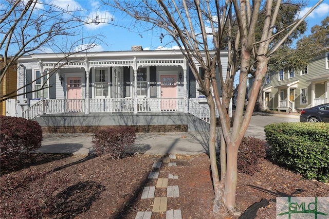 view of front of house featuring covered porch and a chimney