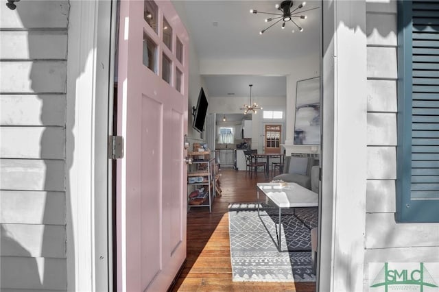 hall featuring an inviting chandelier and wood finished floors