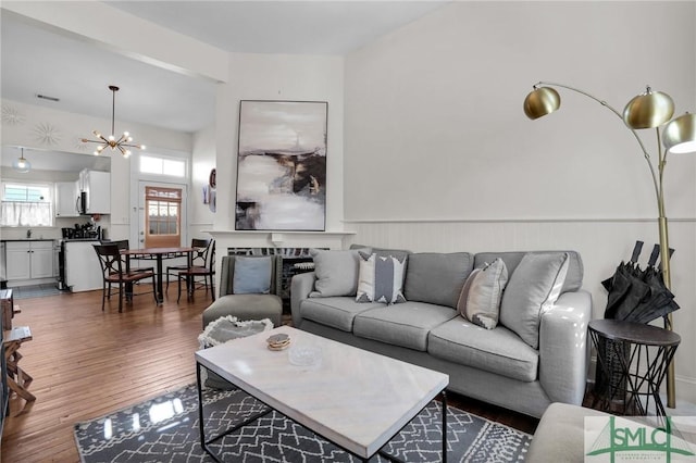 living area featuring a notable chandelier, a fireplace, and wood-type flooring