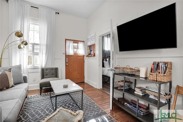 living area with wainscoting and wood finished floors