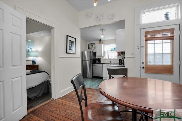 dining area with dark wood finished floors and wainscoting