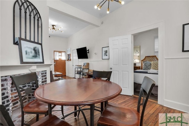 dining room with a notable chandelier, a fireplace, and wood-type flooring