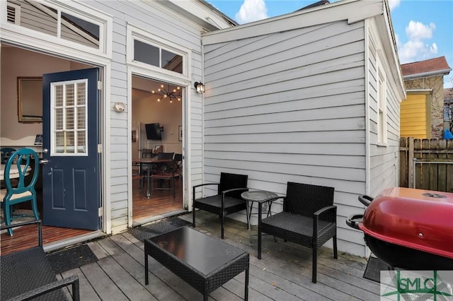 wooden terrace featuring a grill and fence