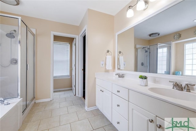 bathroom with double vanity, a stall shower, and a sink