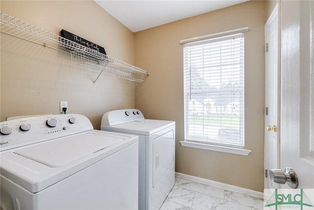 laundry room featuring laundry area, washing machine and dryer, marble finish floor, and a healthy amount of sunlight