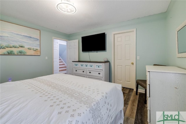 bedroom featuring dark wood-style flooring and a textured ceiling