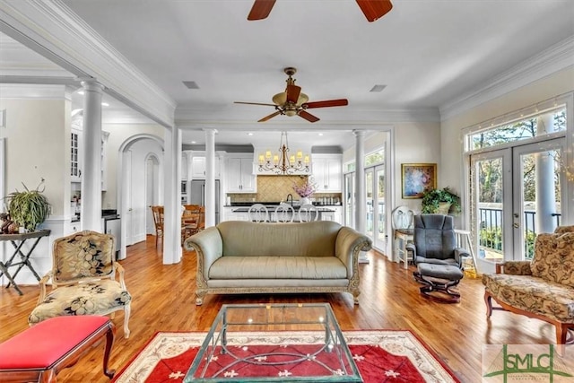 living area with decorative columns and ceiling fan