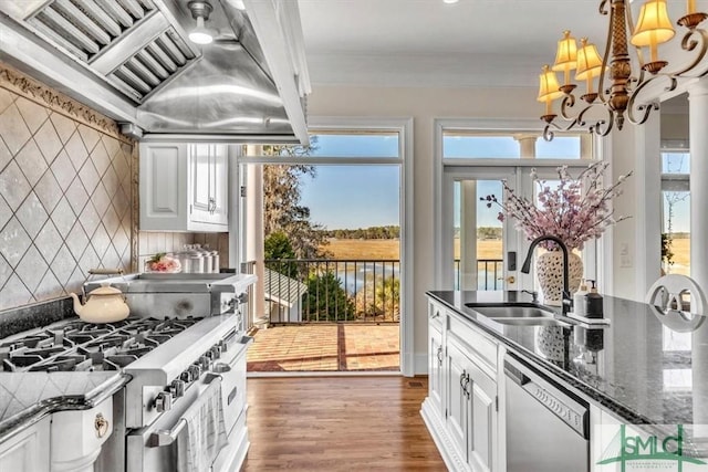 kitchen with wood finished floors, a sink, custom range hood, high end stainless steel range, and dishwasher