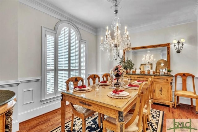 dining space featuring crown molding, a notable chandelier, and light wood-style floors