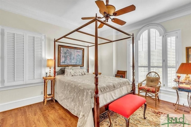 bedroom featuring wood finished floors, baseboards, and ornamental molding