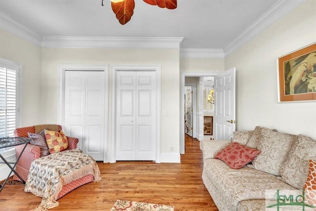 living area with a ceiling fan, light wood-style flooring, and crown molding