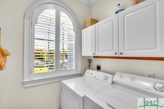 washroom with crown molding, washing machine and dryer, and cabinet space