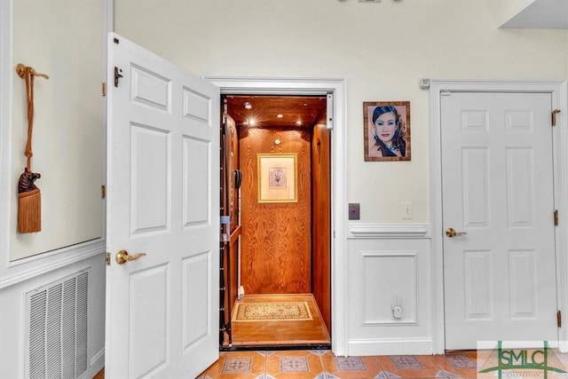 hallway featuring visible vents and wainscoting