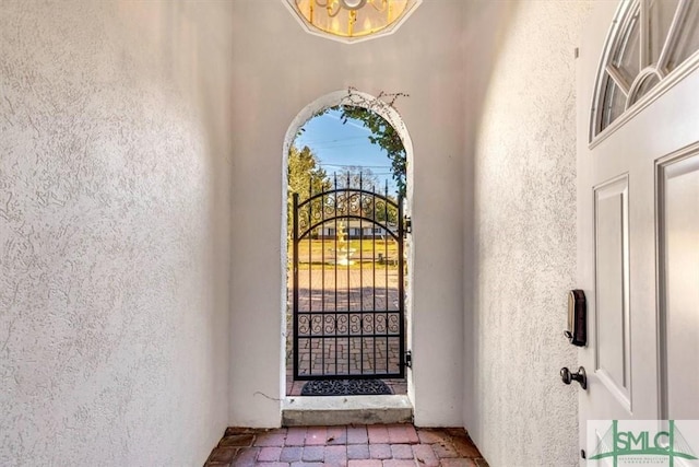 property entrance featuring a gate and stucco siding