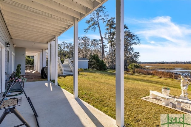 view of patio featuring stairway and a water view