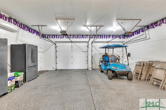 garage featuring an AC wall unit, a garage door opener, and freestanding refrigerator