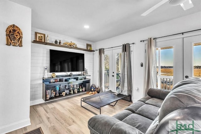 living room featuring french doors, baseboards, visible vents, and wood finished floors