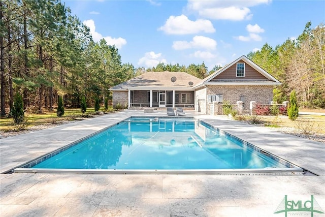 pool with a patio area and a sunroom