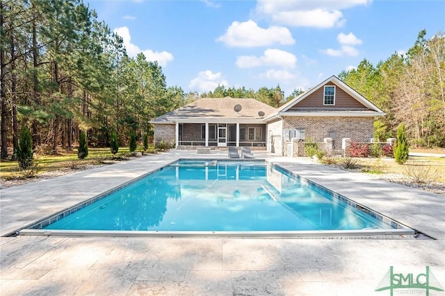 outdoor pool with a patio and a sunroom