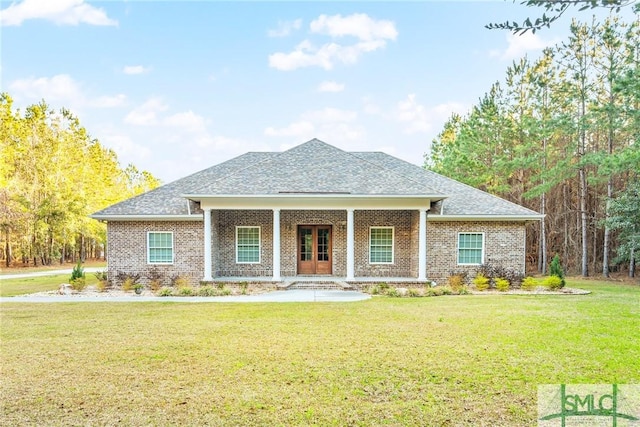 view of front facade with a front yard, covered porch, and brick siding