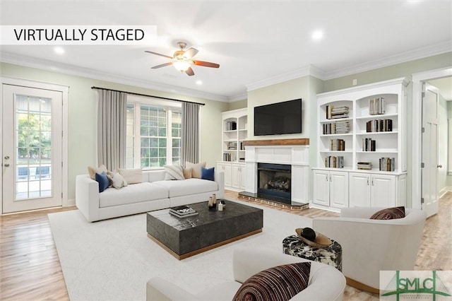 living room featuring light wood finished floors, a healthy amount of sunlight, and a ceiling fan