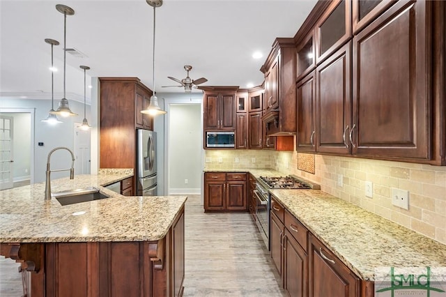 kitchen featuring visible vents, a peninsula, ceiling fan, a sink, and appliances with stainless steel finishes