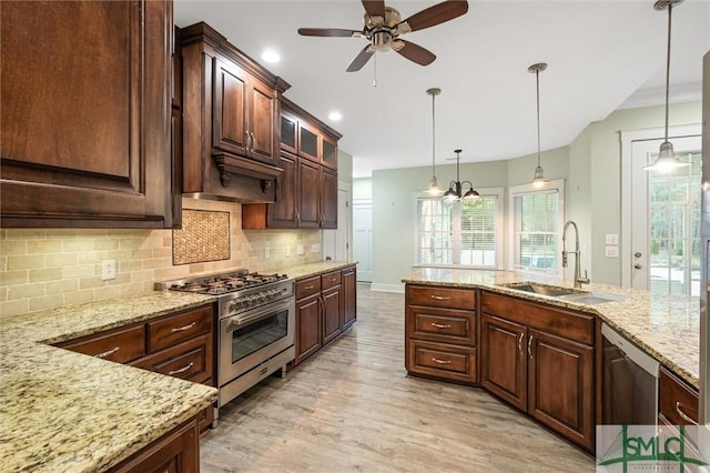 kitchen with pendant lighting, a ceiling fan, a sink, appliances with stainless steel finishes, and decorative backsplash