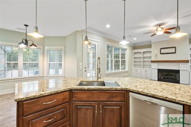 kitchen with light stone counters, a sink, ornamental molding, and stainless steel dishwasher